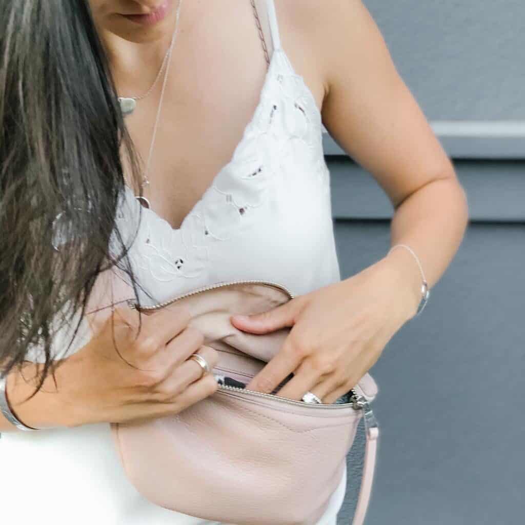 Signed Samantha's COVID-friendly must haves includes a pink belt bag that she is wearing across her body, over her shoulder. The bag is pink and leather.