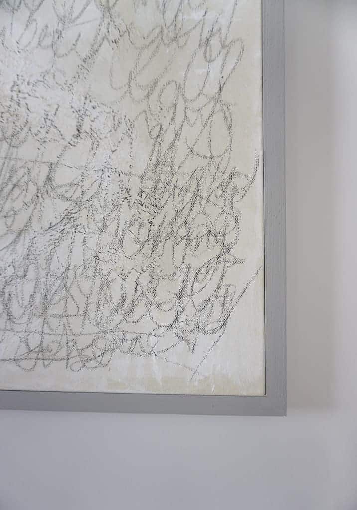 a close of of Signed Samantha's D.I.Y canvas frame. It is a thin grey frame around her canvass.