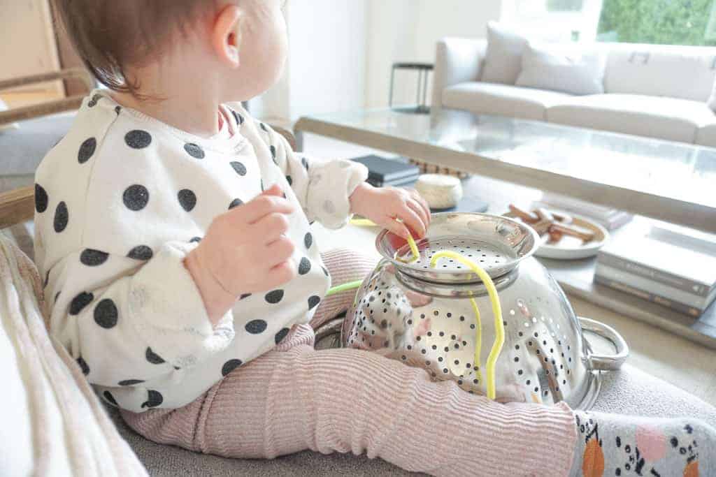 Signed Samantha's Easy and Free Toddler Activities includes playing with pipe cleaners and a colander - pictured here