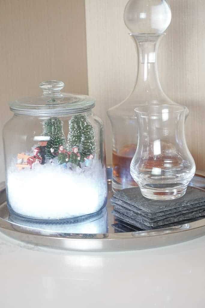 D.I.Y Christmas Terrariums sitting on a tray with a cocktail glass and decanter