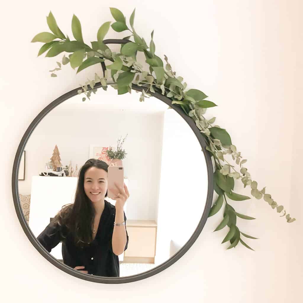 How to Make your home feel more festive includes adding greens throughout like Signed Samantha did on her mirror pictured here - there is eucalyptus and other greens.