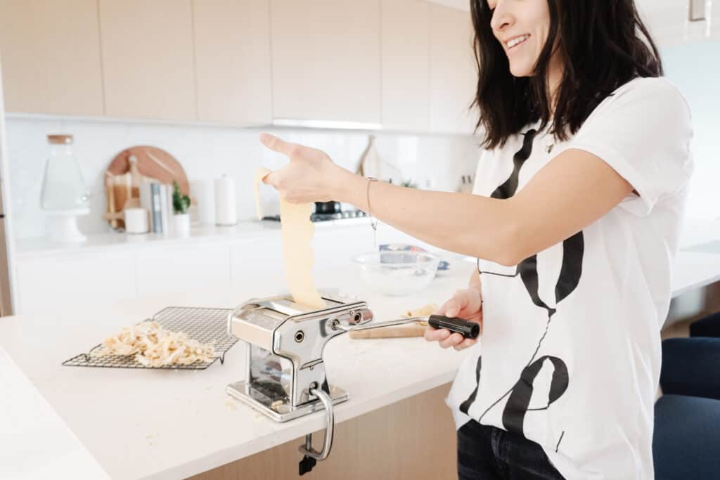Signed Samantha making Homemade Gluten-Free Pasta cranking the pasta through a pasta machine