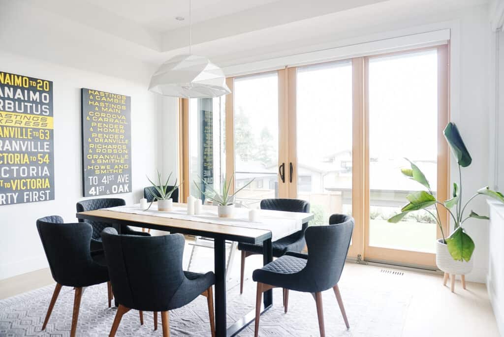splurge vs. save on a dining table? signed samantha's audience picked splurge, but this is where she may save. her dining room is pictured with five chair and one highchair as well as a white pendant light and black and yellow bus rolls on the wall.
