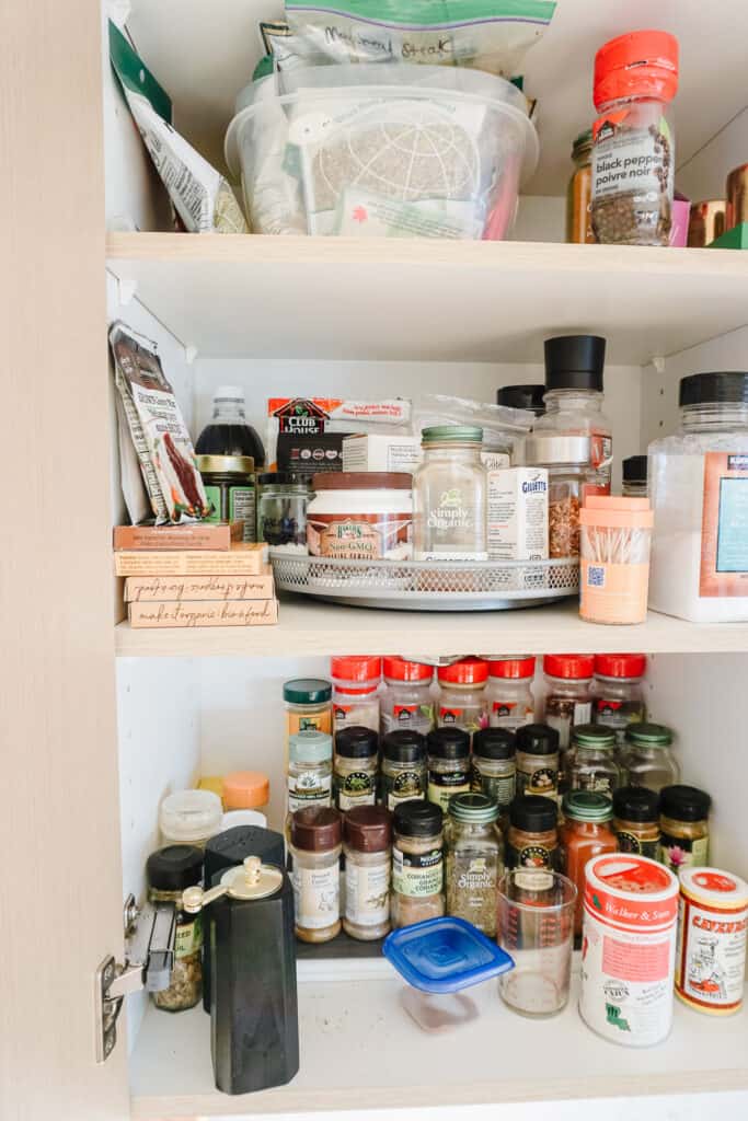 Signed Samantha is talking about three things I want to organize one of which includes her spice cupboard which is pictured here. spices tiered on the first shelf, a turn table of baking goods on the second shelf, and a container on the third shelf. It needs some TLC