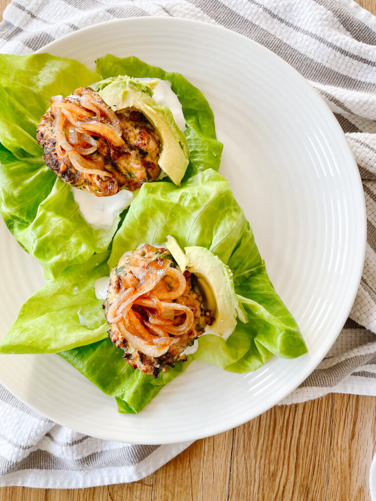 Delicious turkey burgers sitting on a bed of lettuce