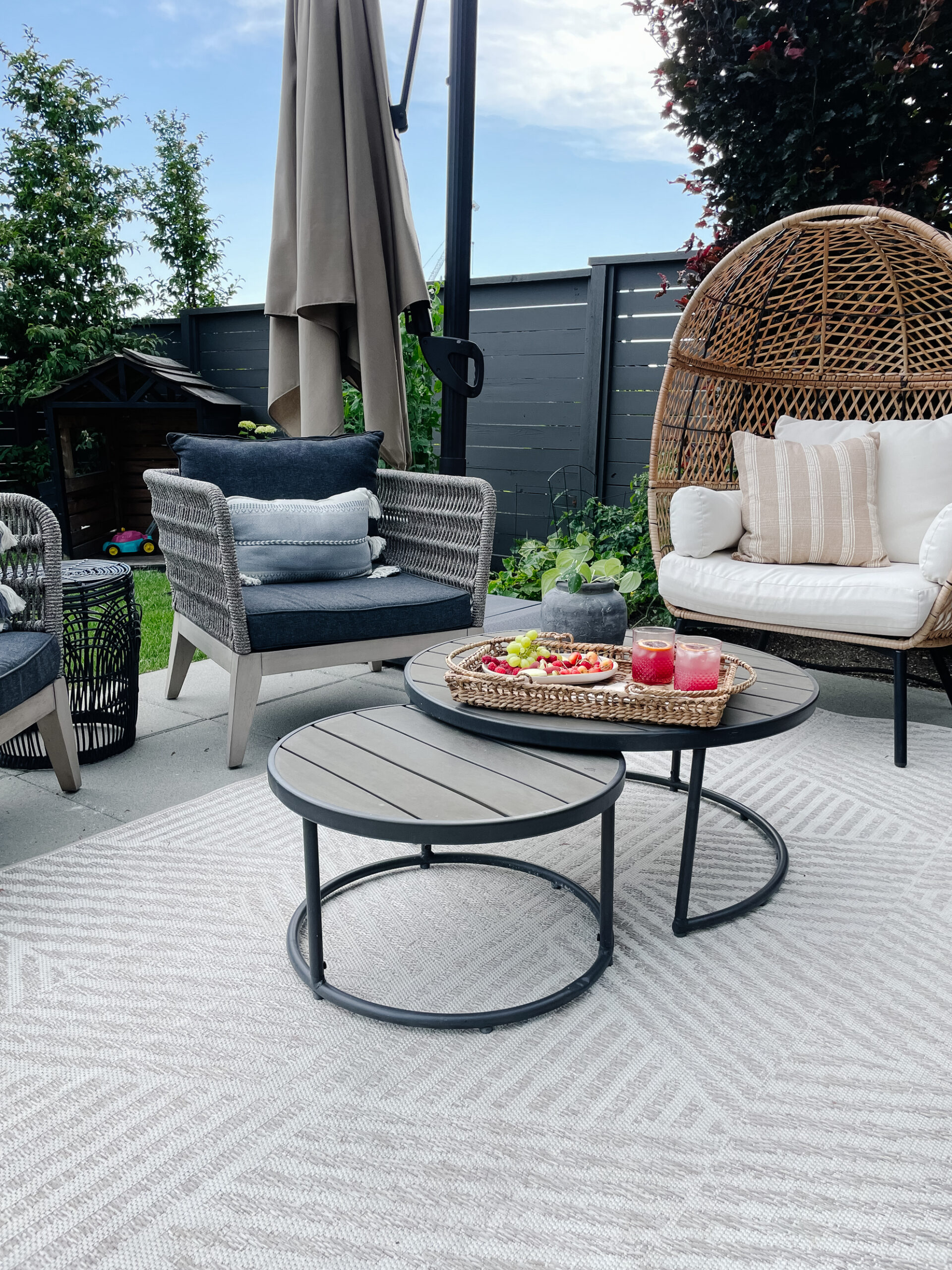 backyard patio space with outdoor furniture a rug and throw pillows, table and food set up