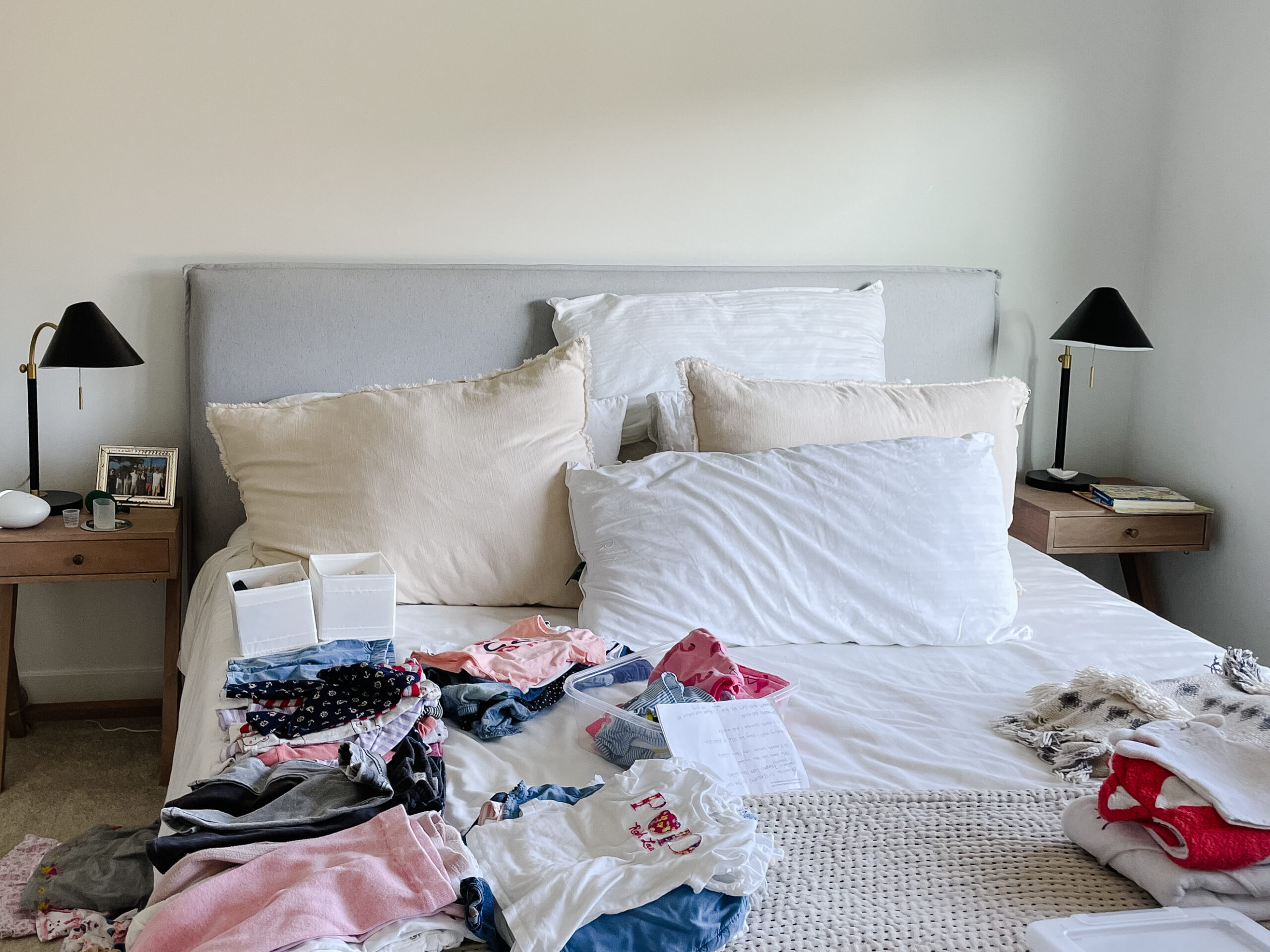 location of home office 2.0 - a picture of a bed with a bunch of kids clothes on it
