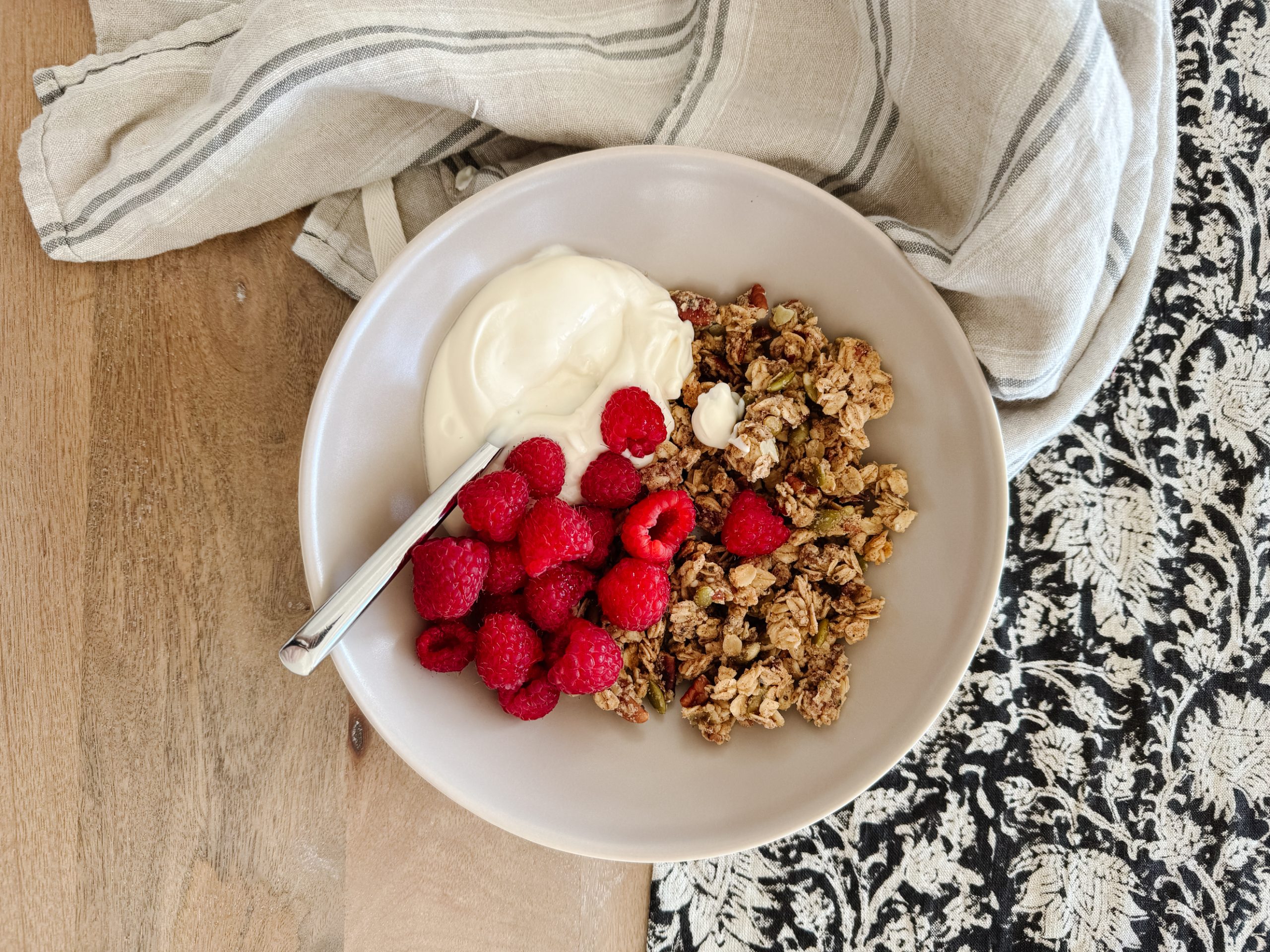 gluten-free granola in a bowl with raspberries and yogurt
