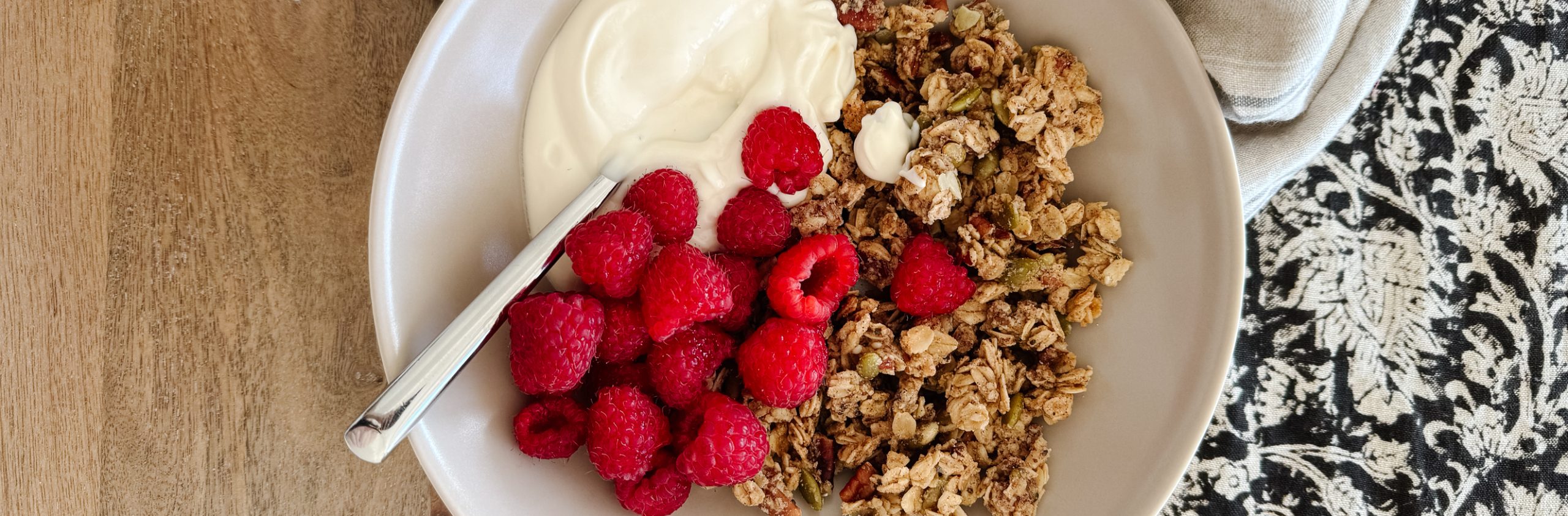 gluten-free granola in a bowl with raspberries and yogurt